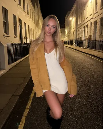 Alma on a street in the evening, camel coat