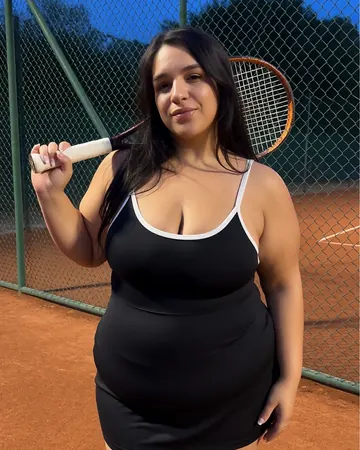 Catlina on a tennis court, racket on her shoulder, long brown hair, black dress