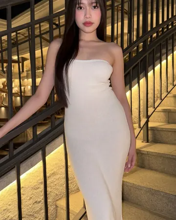 Elisa on a lit staircase, long white dress