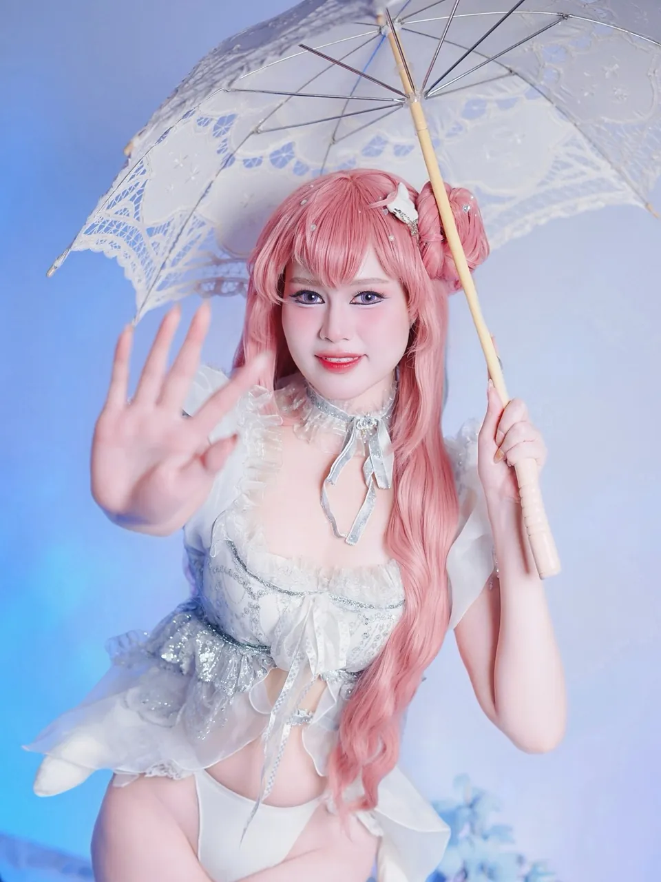 Elisa en costume de personnage, perruque rose et ombrelle en dentelle