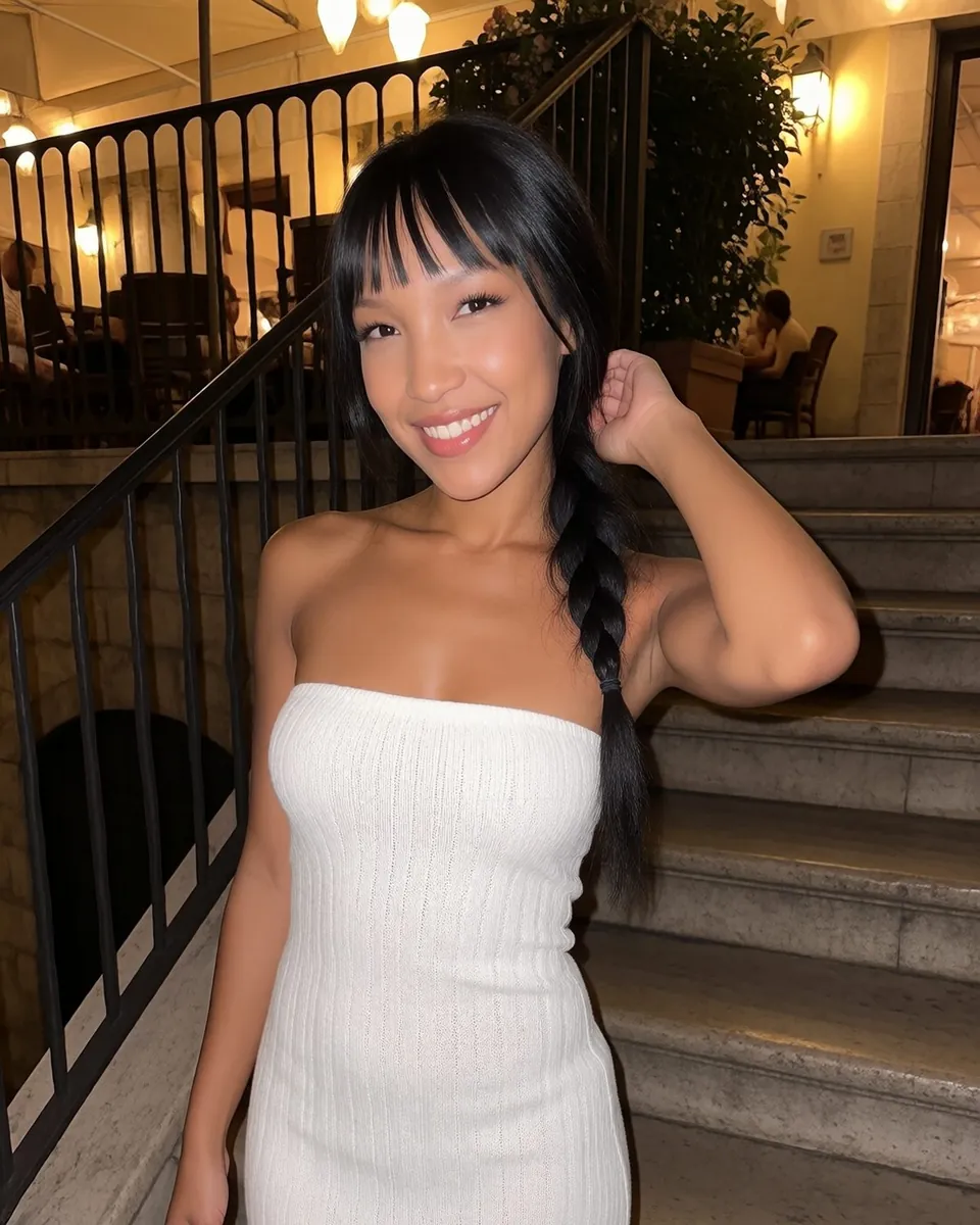 Jade dans un escalier éclairé le soir, robe blanche, une main dans les cheveux