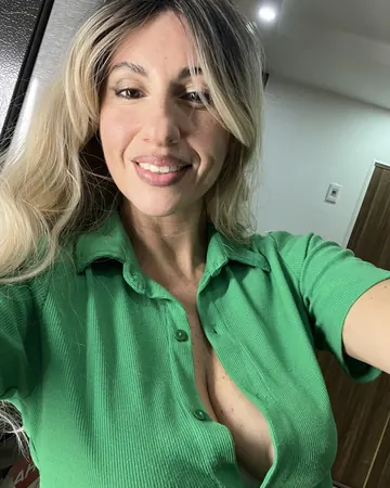 Lena taking a selfie, blonde hair, green shirt, big smile