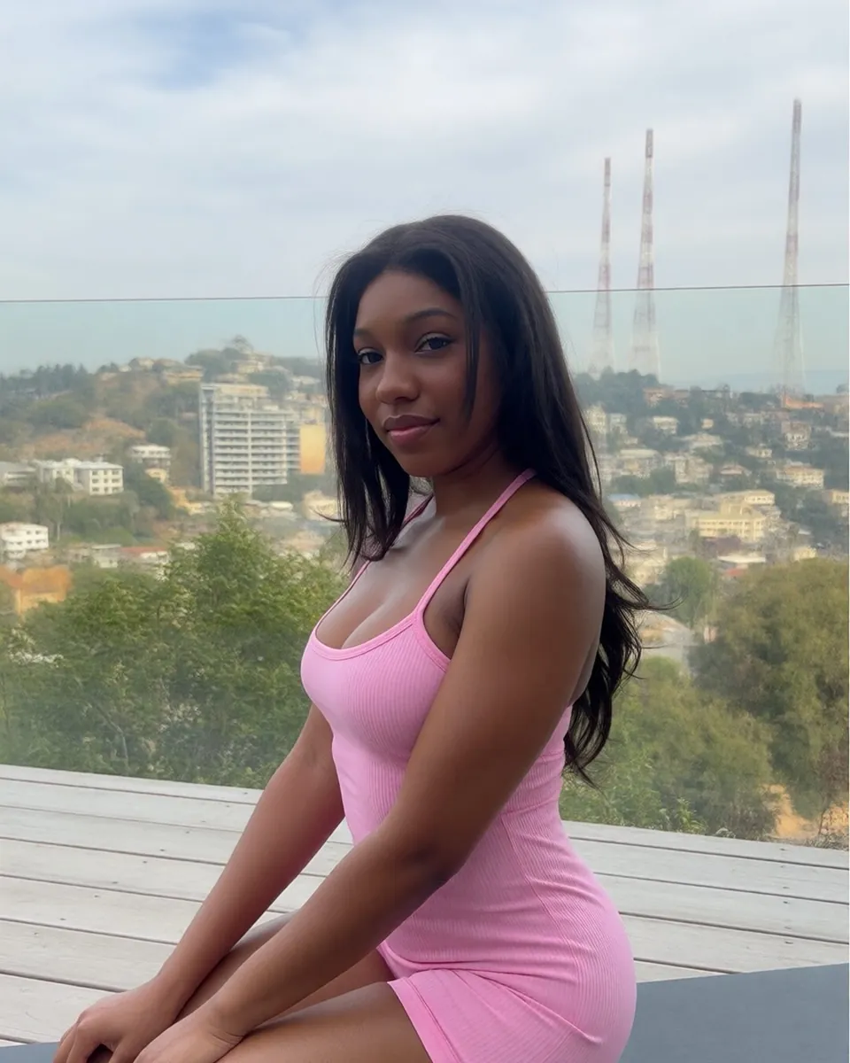 Maya agenouillée sur un tapis de sport sur une terrasse, combinaison rose