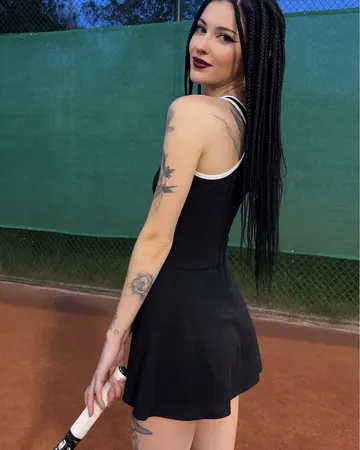 Vera on a tennis court, black dress