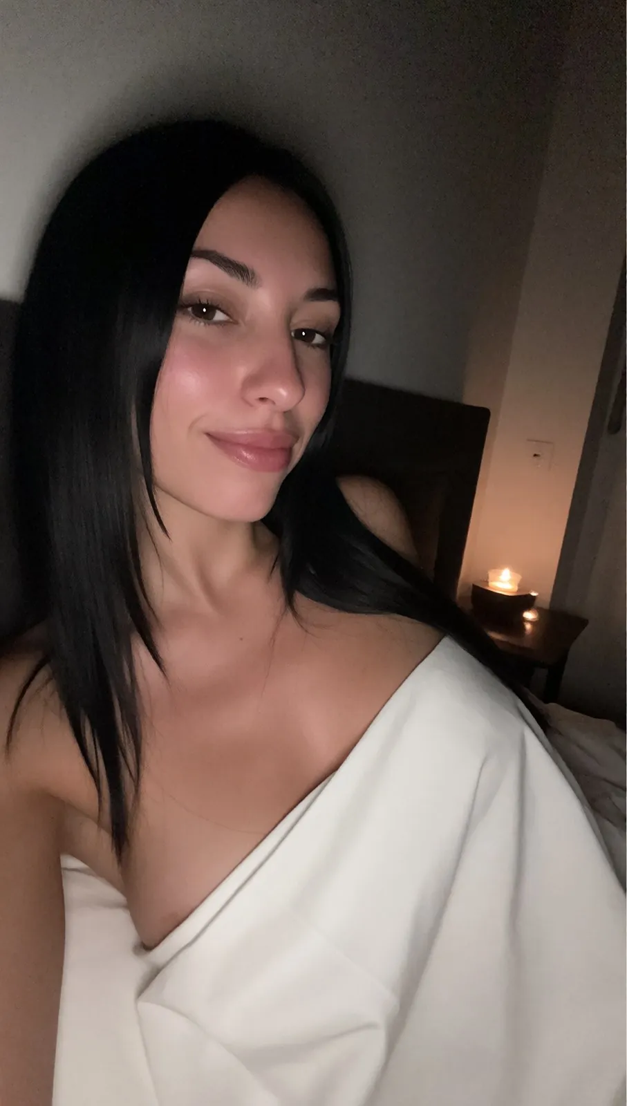 Zoe le soir sous une couverture blanche, une bougie allumée